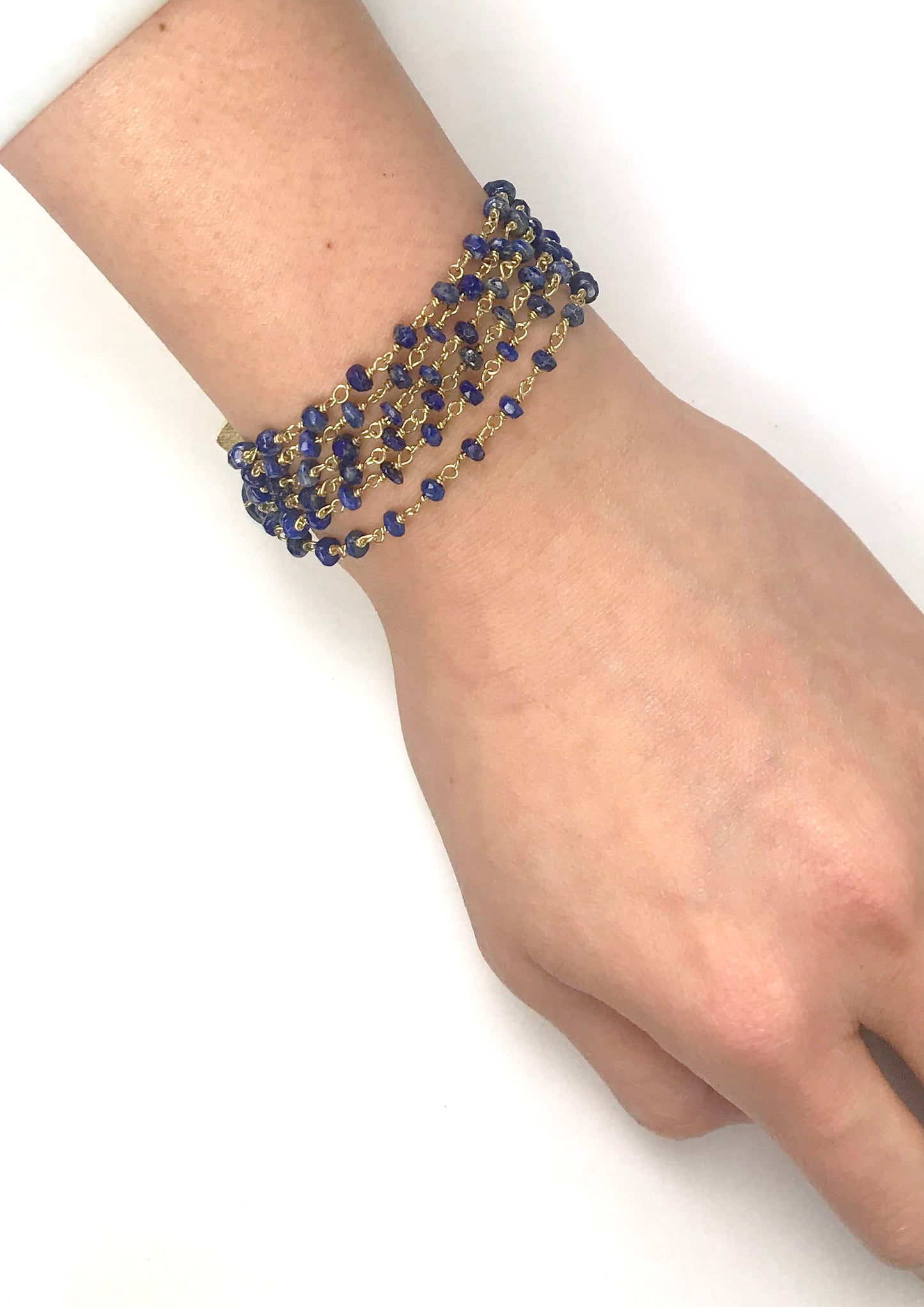 Gena Myints Lapis Lazuli Bracelet features gold and blue multi-strands, a lobster clasp, and a heart-shaped charm.
