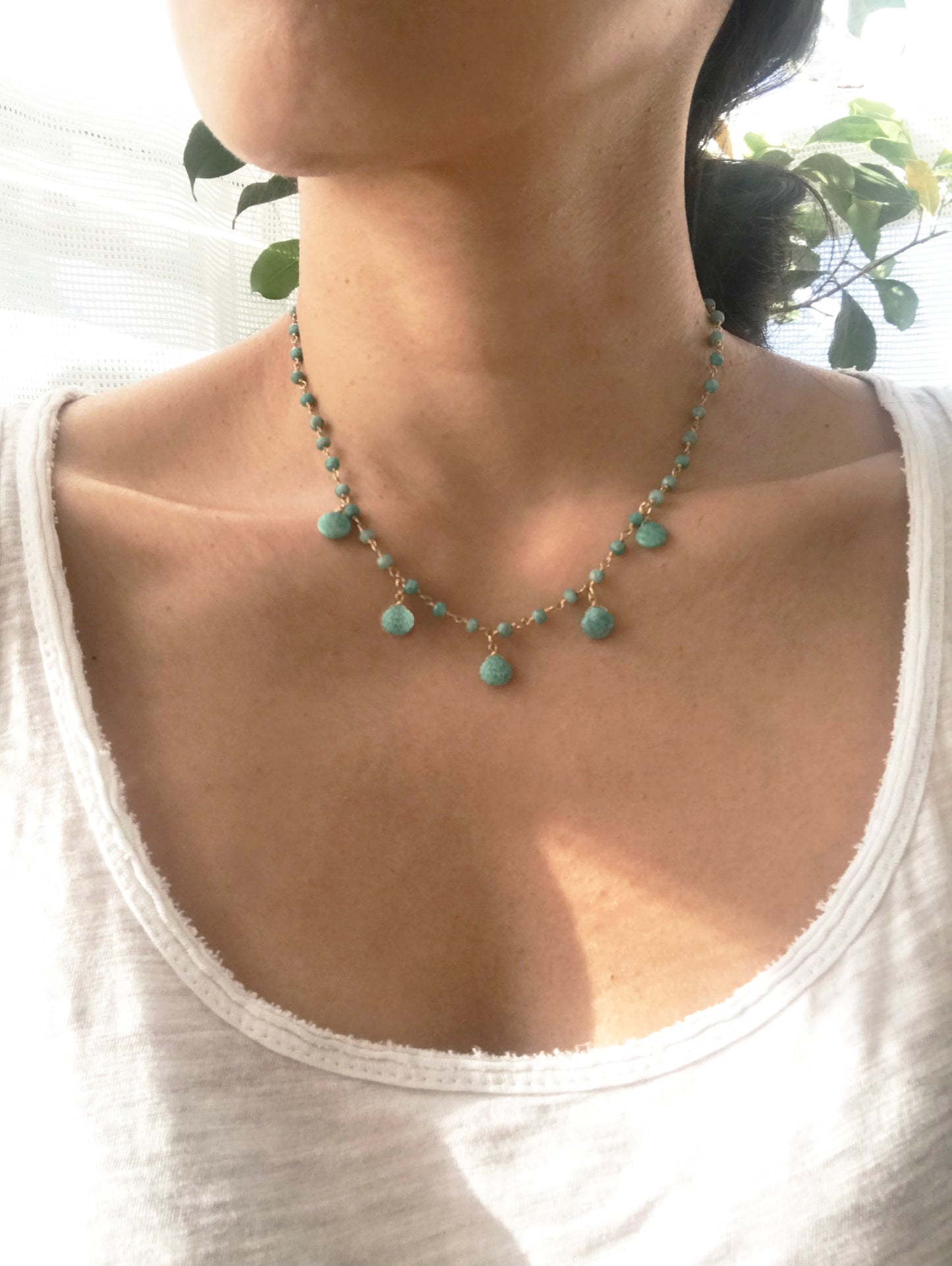 Gena Myints Amazonite Droplet Vermeil Necklace features a gold chain adorned with turquoise beads and teardrop pendants.