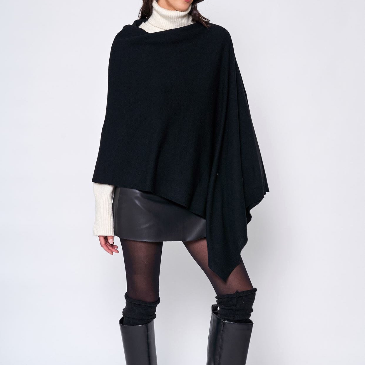Someone wearing the Take With Me Travel Poncho by Ellison + Young with plaid pants against a plain white background.