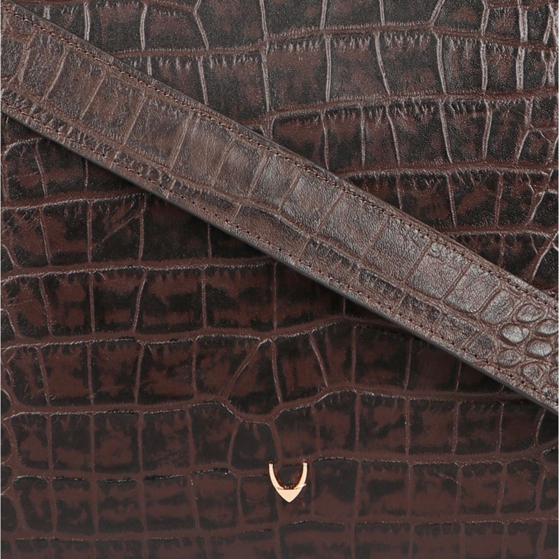 A Hidesign leather handbag in black features a textured design, rectangular cutout handle, and detachable shoulder strap.
