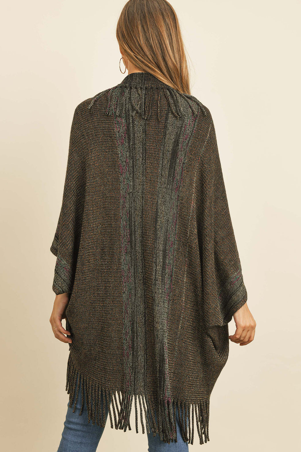 Someone is wearing a Fringe Stripe Open Front Kimono by Riah Fashion over a beige top and ripped jeans, standing against a plain background.