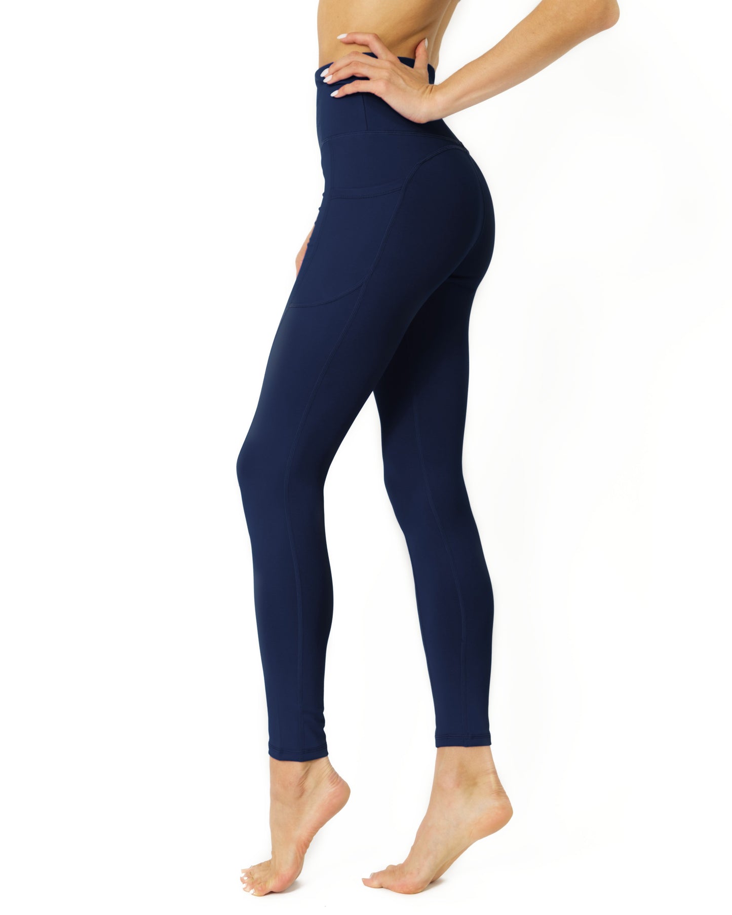 A person wearing Savoy Actives High Waisted Yoga Leggings in Navy Blue and black shoes stands against a white background.
