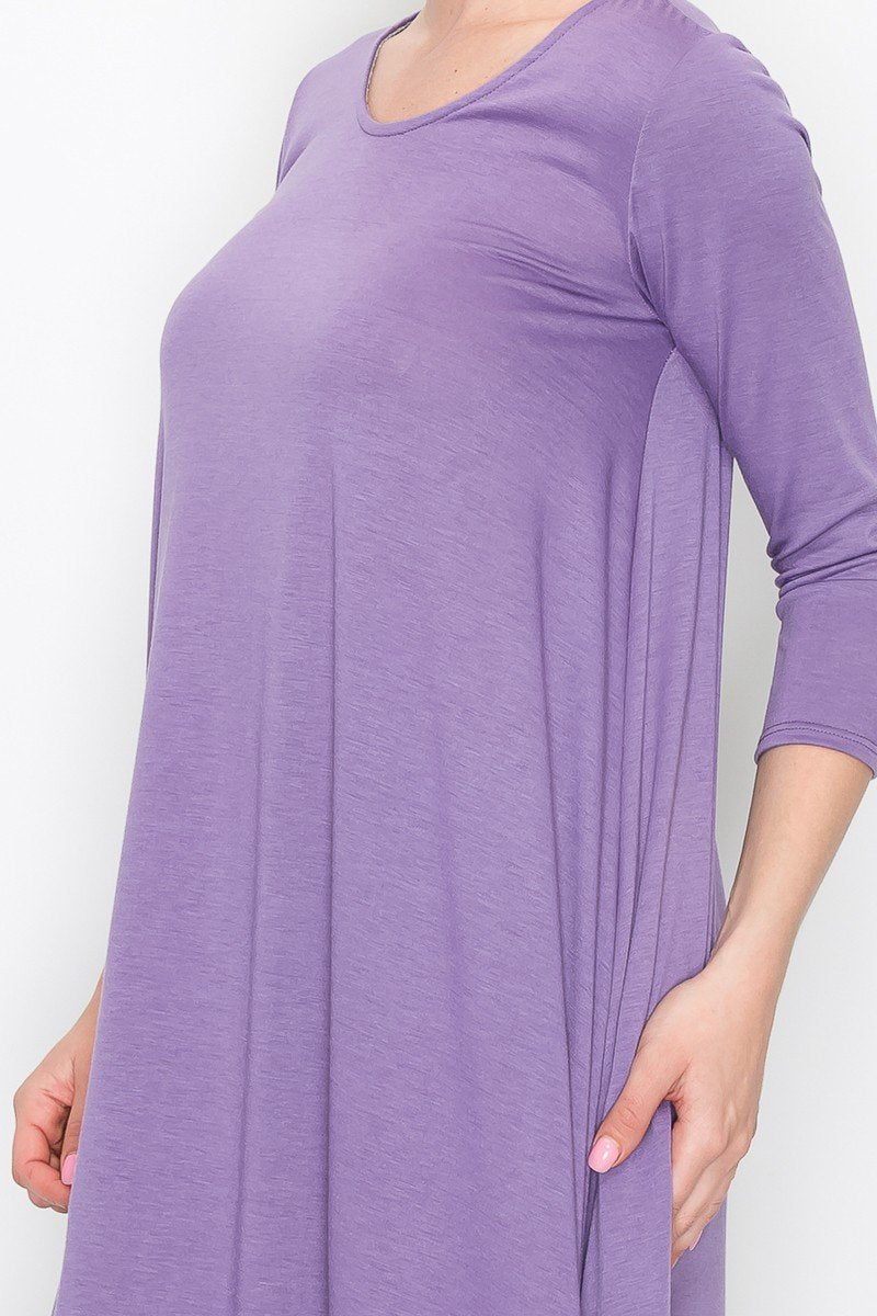 A person models the Stylespect Solid Balloon Dress in purple with its long sleeves and asymmetrical cut, paired with beige heels, all set against a plain white background.