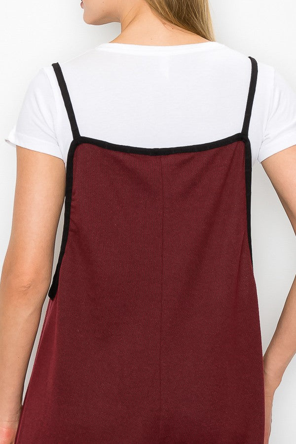 A person is wearing a white T-shirt and the Cropped Bottom Wide Leg Oversized Jumpsuit in Burgundy from Stylespect, standing against a plain white background.