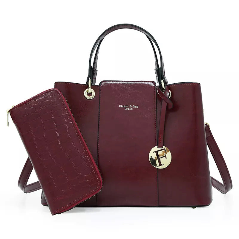 The Aaliyah Faux Crocodile Handbag Set by Savoy Active includes a maroon handbag with black handles and a small charm, plus a matching wallet.