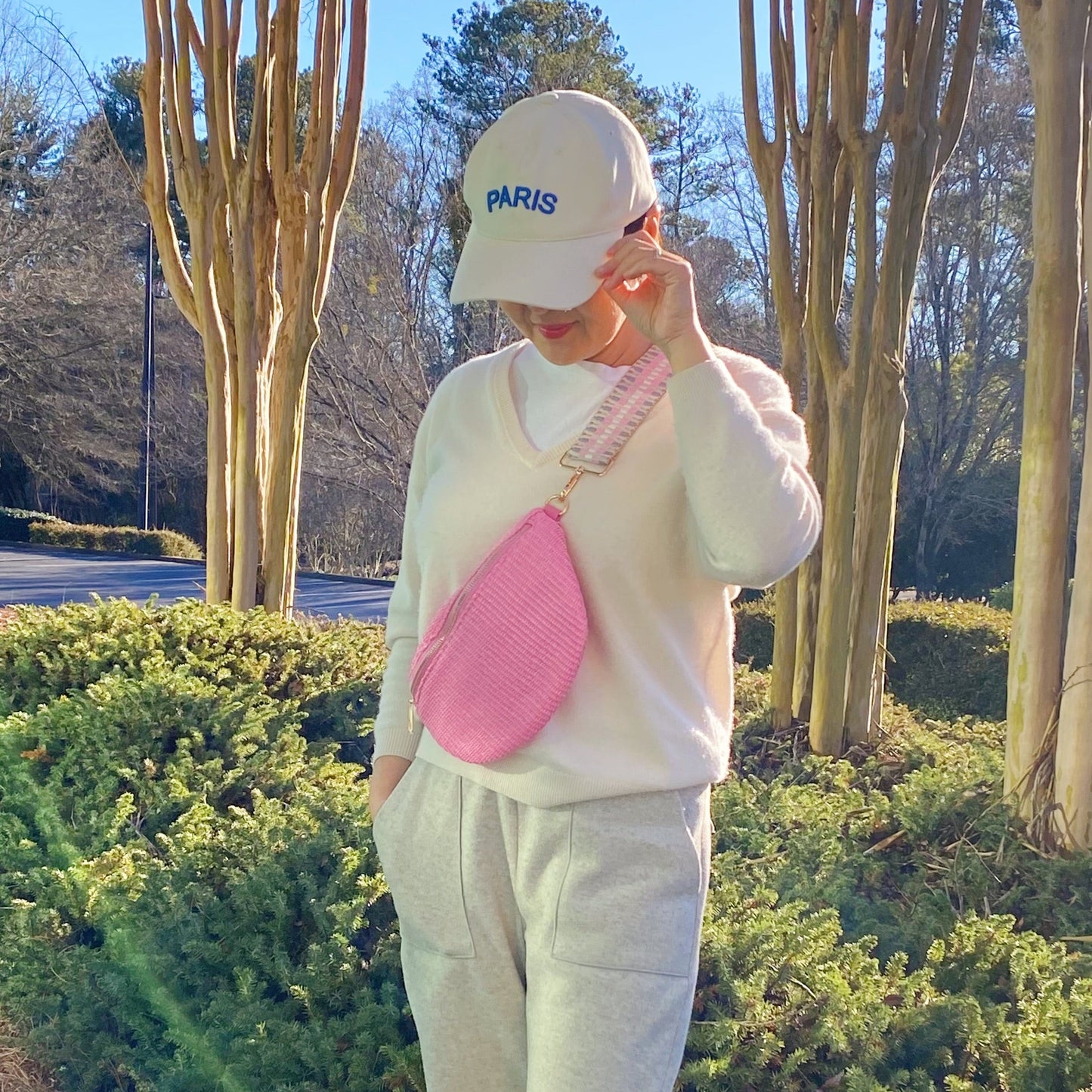 Four Bahama Breeze Fit All Sling Bags by Ellison + Young in pink, black, beige, and green with unique patterned straps are displayed on a white surface.