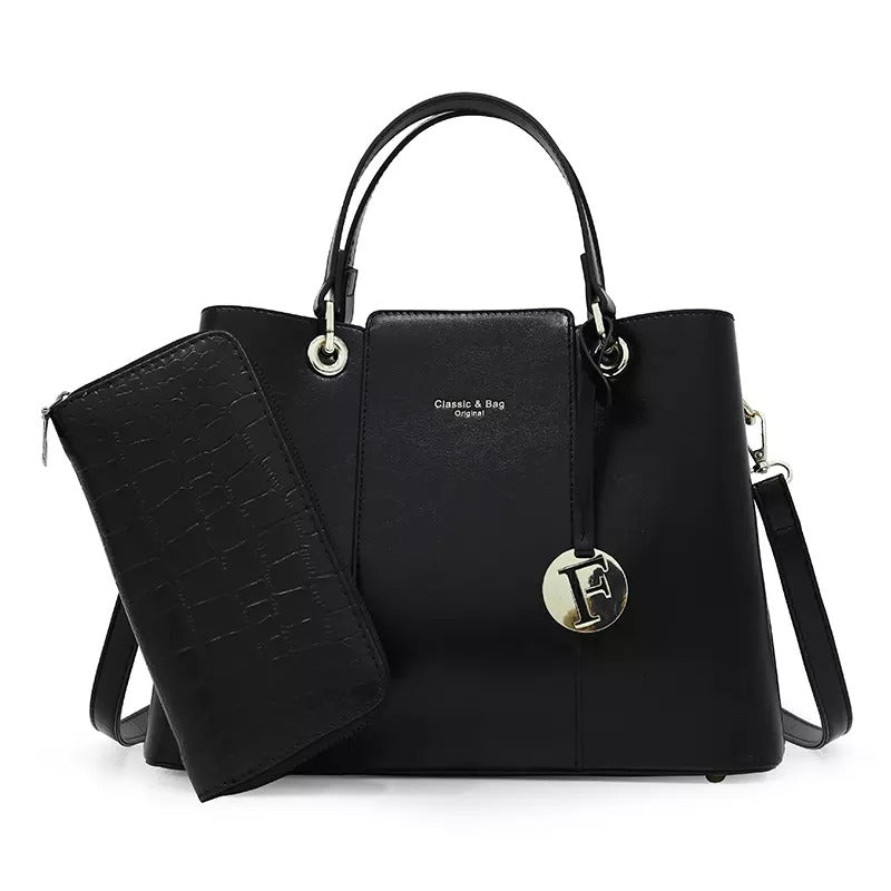 The Aaliyah Faux Crocodile Handbag Set (2-Pack) by Savoy Active includes a black handbag with a short handle, detachable shoulder strap, and circular charm, along with a matching textured wallet.