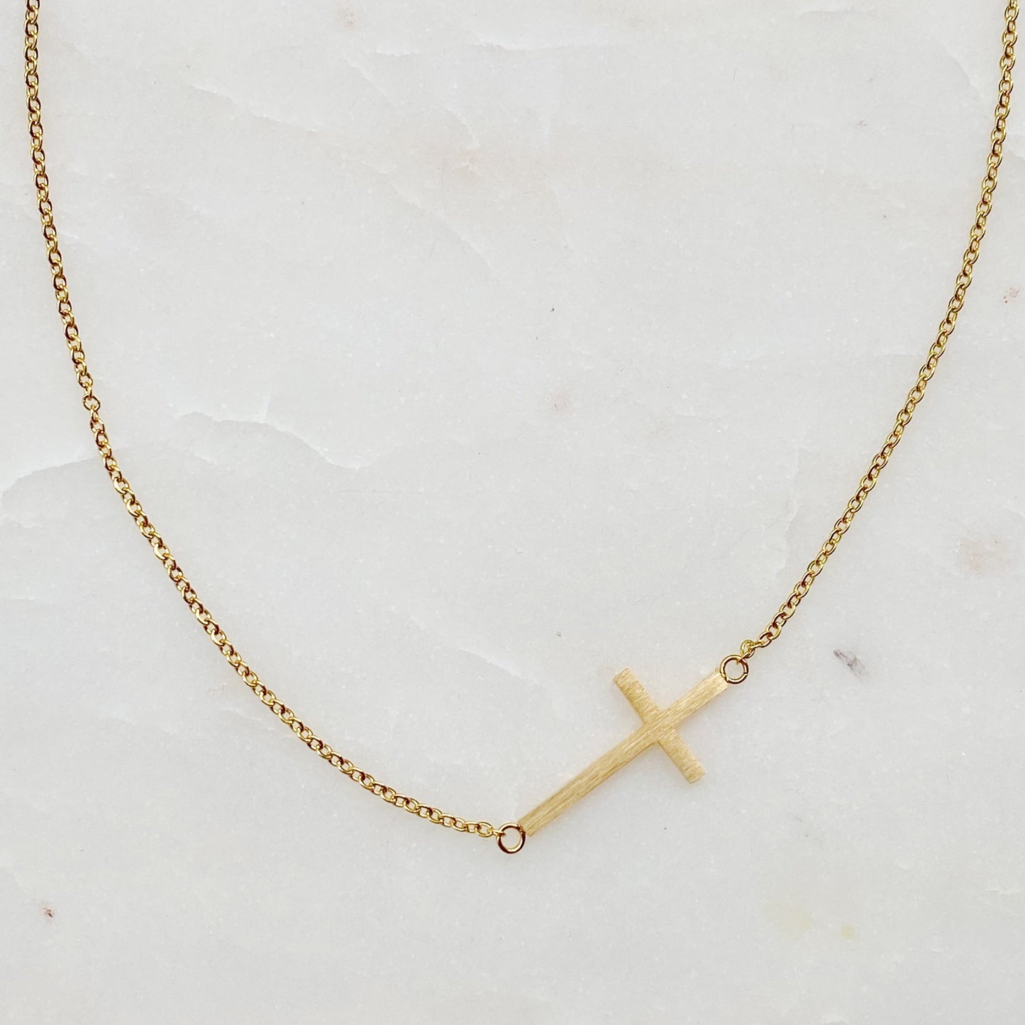 Two Kayla Cross Necklaces from Ellison + Young, one silver and one gold, presented on a white surface.