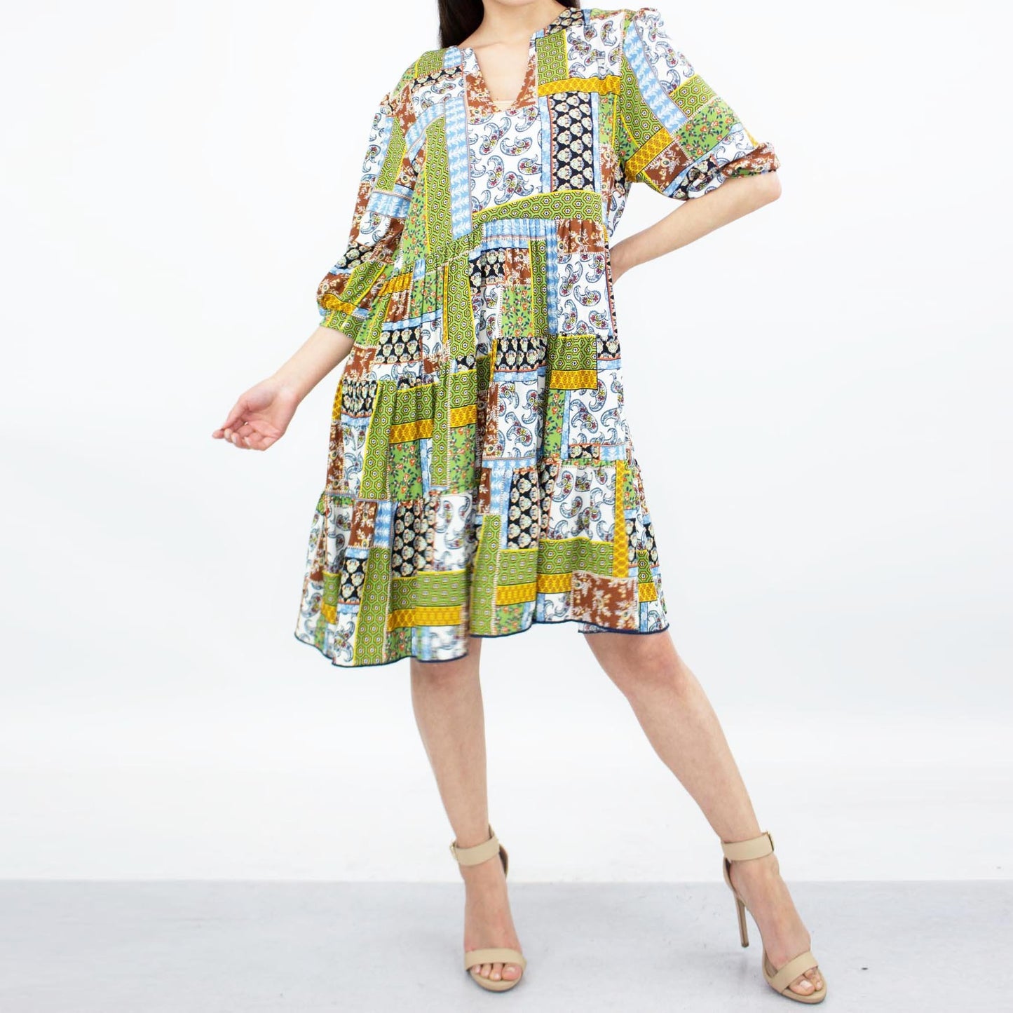 Person wearing a Stylespect Flare Bottom 3/4 Sleeve Dress in green, paired with beige heels, posing against a plain background.