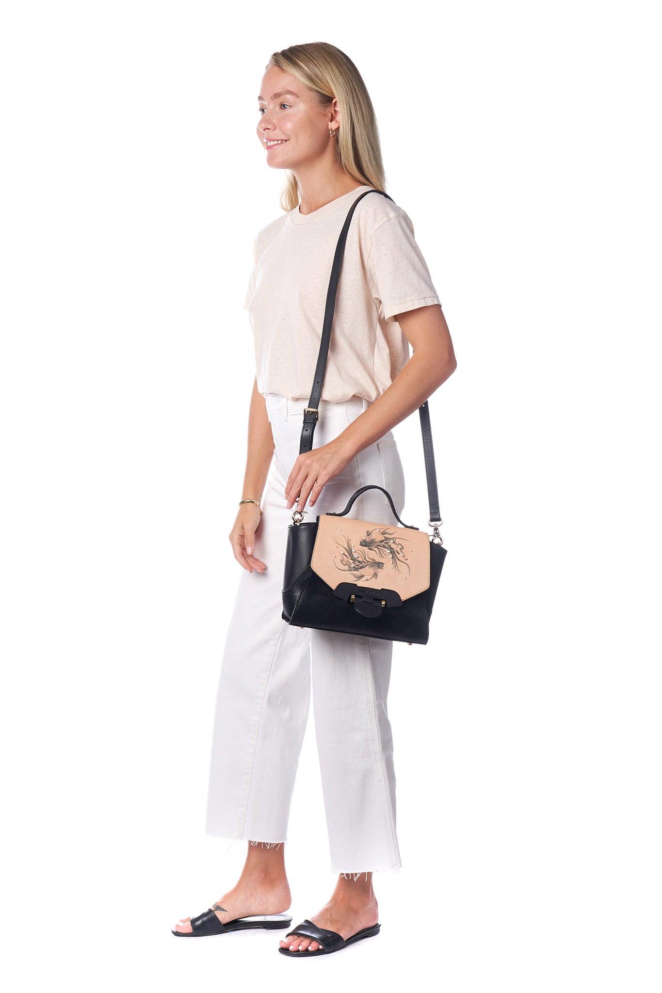 The Koi Small Black Satchel by Bellorita is a handbag with a black body, a tan flap adorned with fish designs, and decorative pearls.