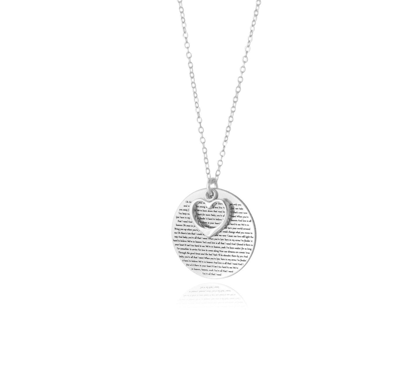 The Words of Love Necklace by Sincerely Silver is a silver piece with a round pendant showcasing printed text and an overlapping heart-shaped cutout.
