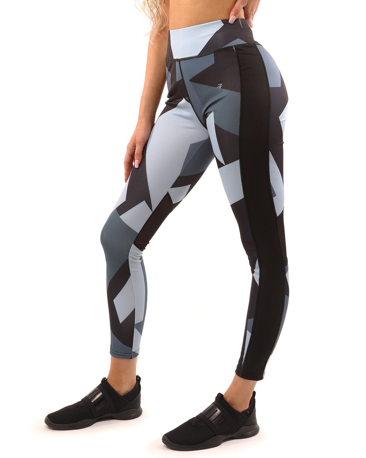 A person wearing the Savoy Active Bondi Set, consisting of geometric-patterned black and grey leggings and a sports bra, stands against a white background.