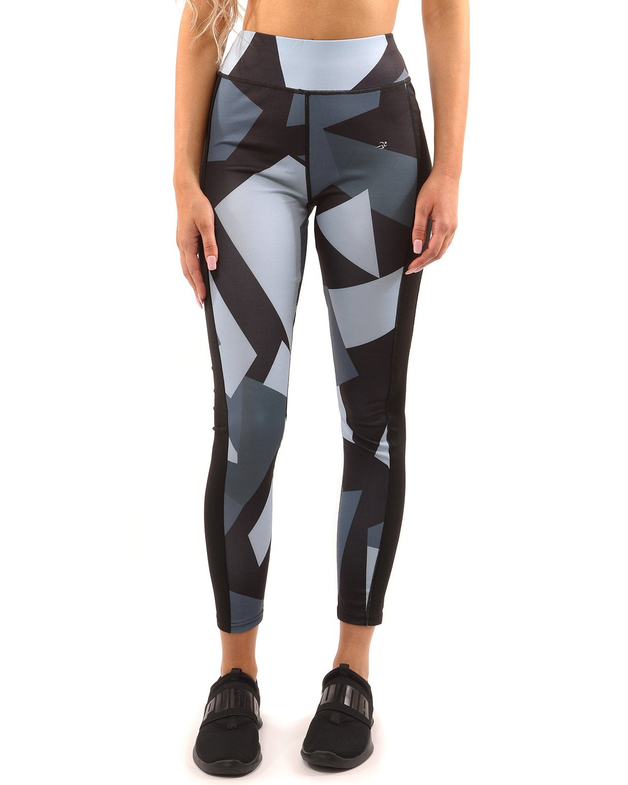 A person wearing the Savoy Active Bondi Set, consisting of geometric-patterned black and grey leggings and a sports bra, stands against a white background.