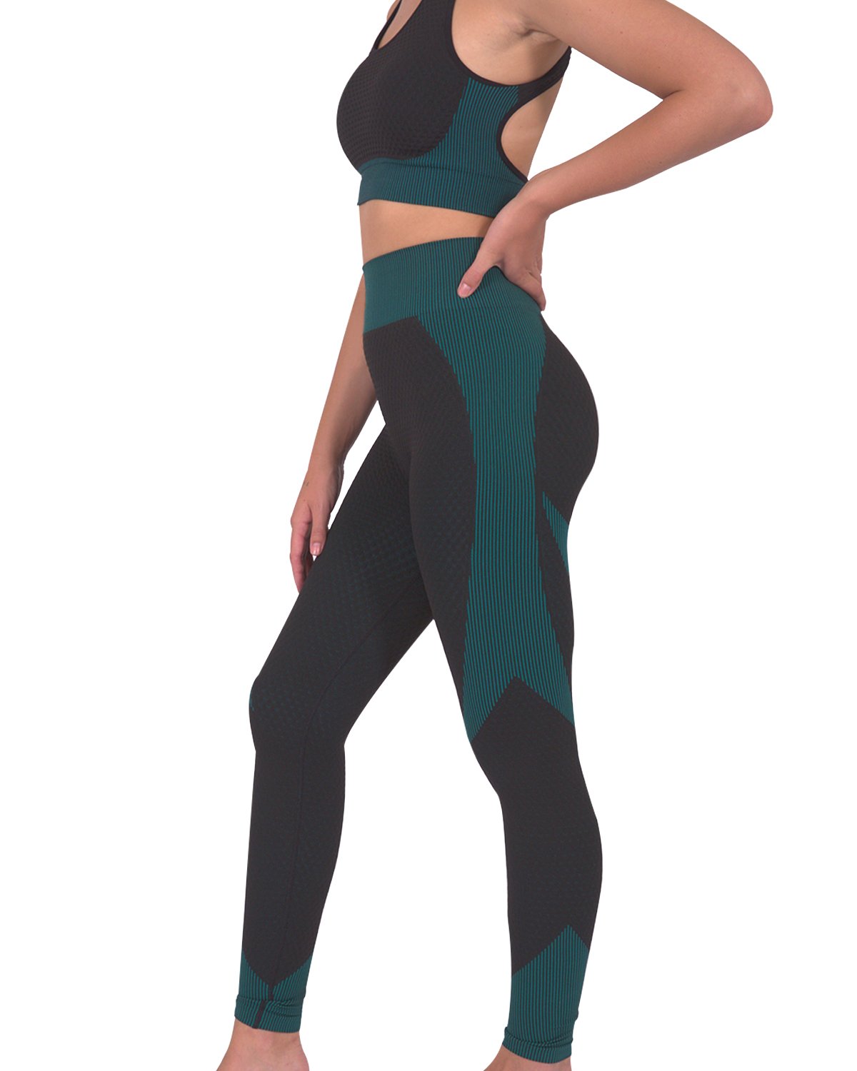 A person wearing Savoy Actives Trois Seamless Legging in Black with Teal Blue and black sneakers stands against a gray textured wall.