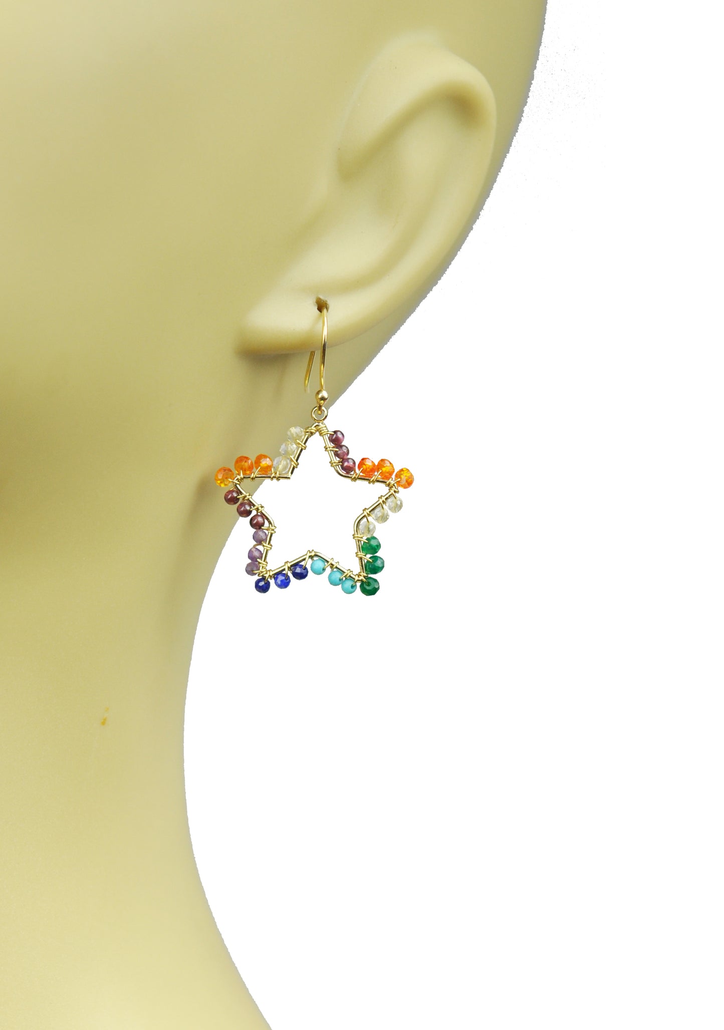 The Chakra Star Vermeil Earrings by Gena Myint feature a gold wire frame in a star shape, adorned with multicolored beads—orange, green, blue, and purple—on a white background.