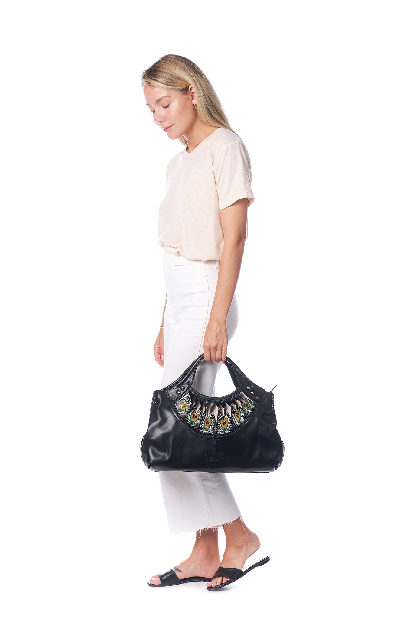 The Bellorita Feather Black Tote is a black leather handbag featuring a decorative peacock feather pattern near the handle, adorned with small metal studs.