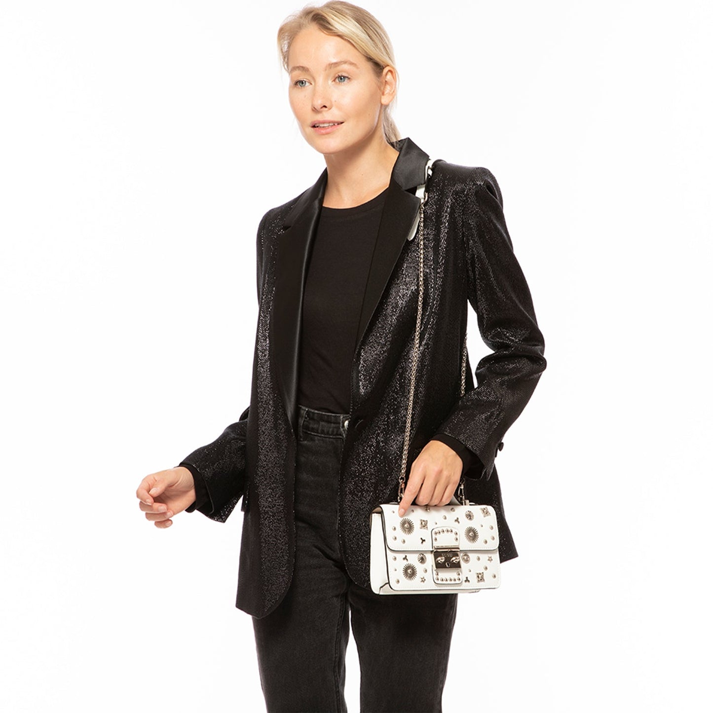 The Hollywood White Leather Crossbody Bag by SUSU features silver stud embellishments, a chain strap, a top handle, and a front clasp with the SUSU brand name.