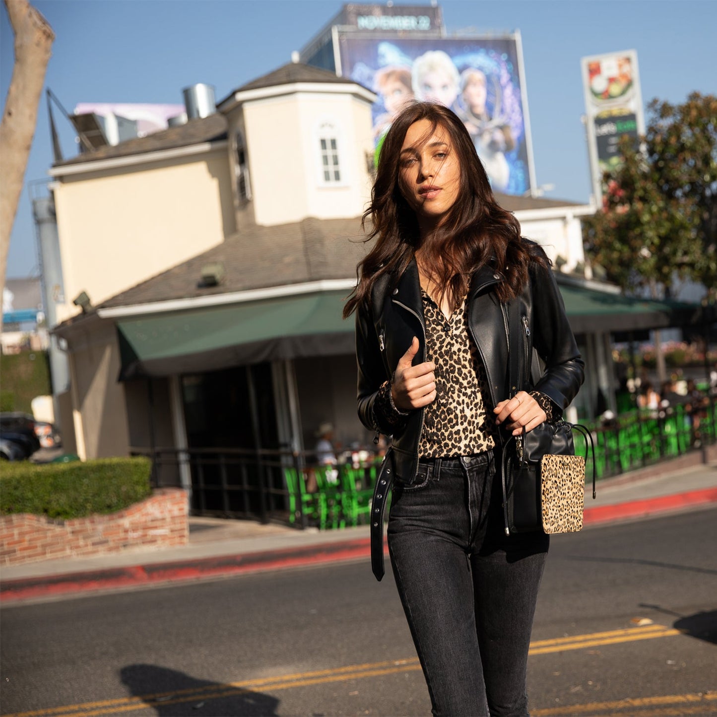 The Patricia Black Leopard Leather Purse by SUSU features a leopard print, black leather accents, drawstring closure, detachable strap, and gold hardware.