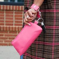 The KEYPER Bright Pink Vegan Leather 2-Piece WRISTLET SET includes a small pink pouch with a zipper, gold clasp, an attached pink strap, and a set of keys.