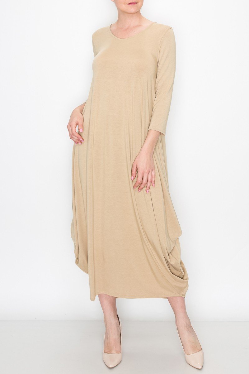 A person poses against a white background wearing the Stylespect Solid Balloon Dress in beige, featuring long sleeves and paired with beige heels, with one hand on their hip.