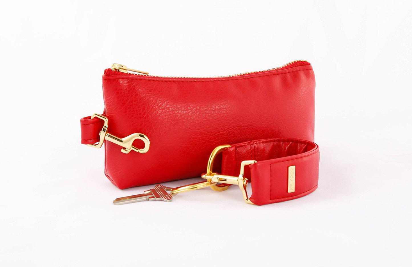 A red vegan leather wristlet set from KEYPER, featuring a gold zipper and detachable strap with gold hardware.