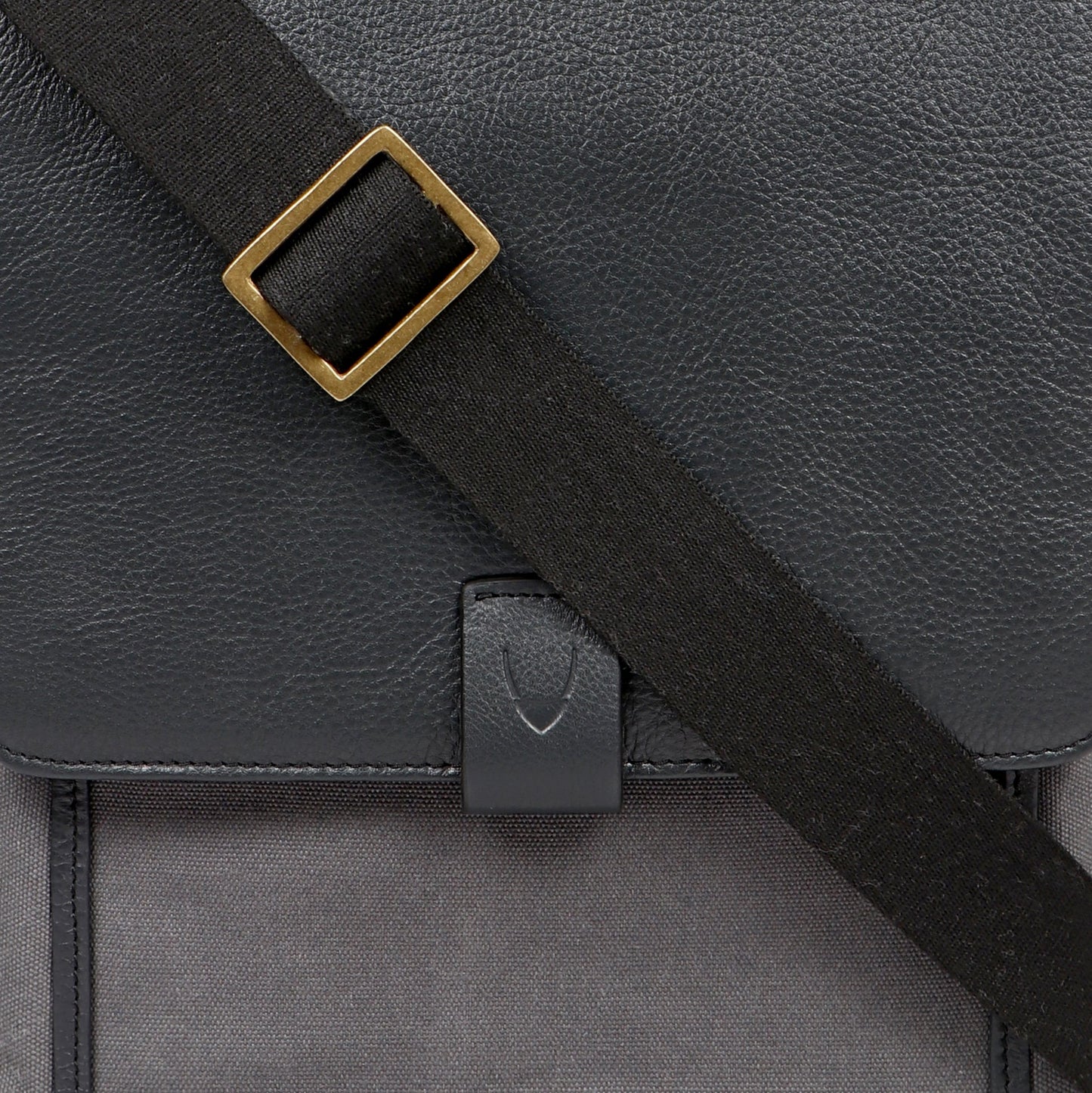 The Aiden Hidesign Blue Genuine Leather and Canvas Crossbody Bag features an adjustable strap and buckle, perfect for men or women as a shoulder, messenger, or travel bag that fits a 10.5 iPad.