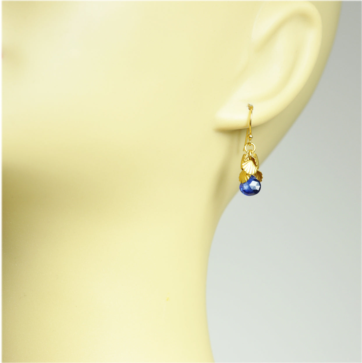 Gena Myints Shell Cluster Blue Sapphire Earrings feature blue gemstones and shell-shaped accents.