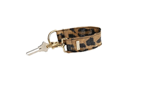 The KEYPER Brown Leopard Vegan Leather Key Ring is a wristlet keychain with a metal key and gold clasp.