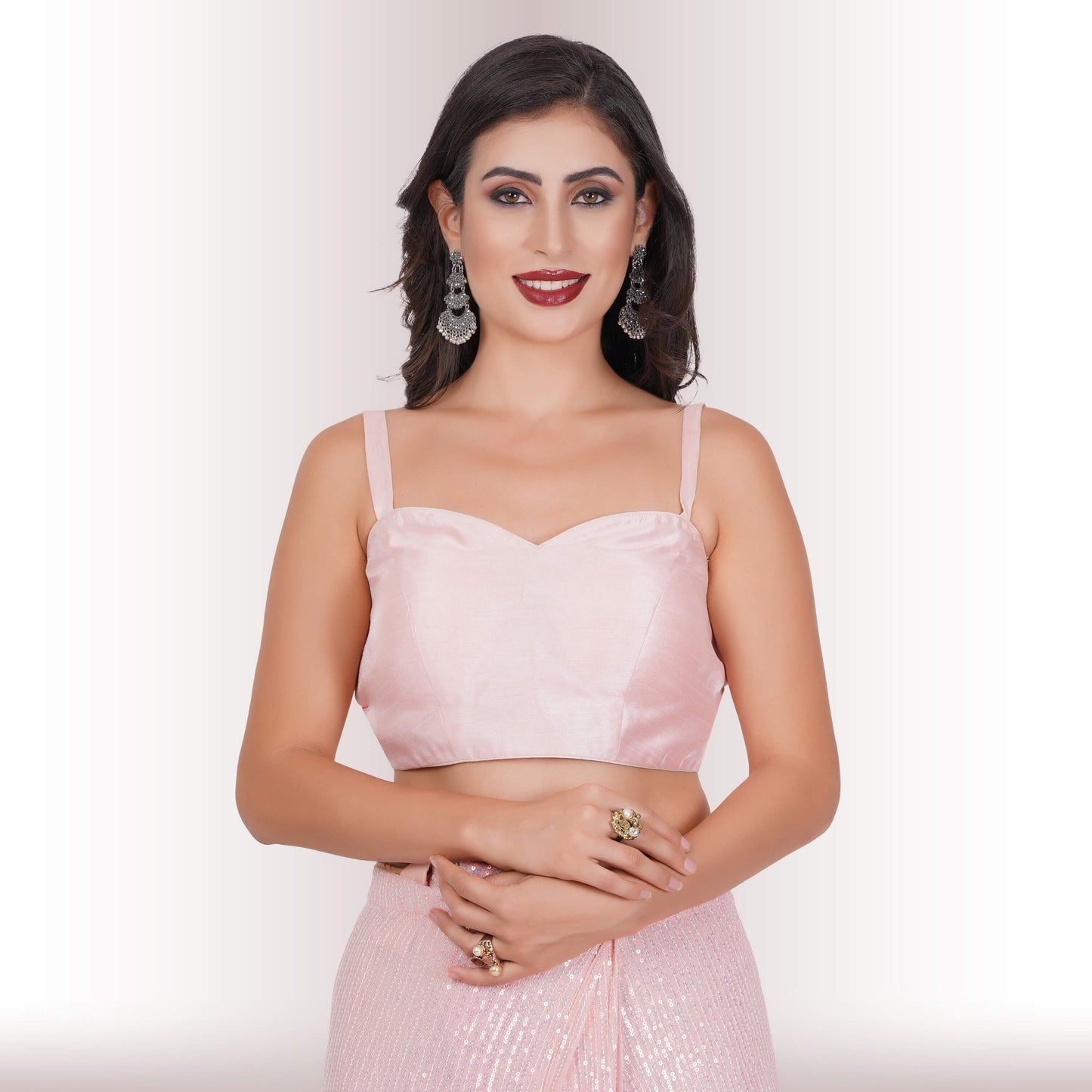 A person wearing Chiros Ready Made Sequin Saree in Blush poses with one hand on their hip against a light background.