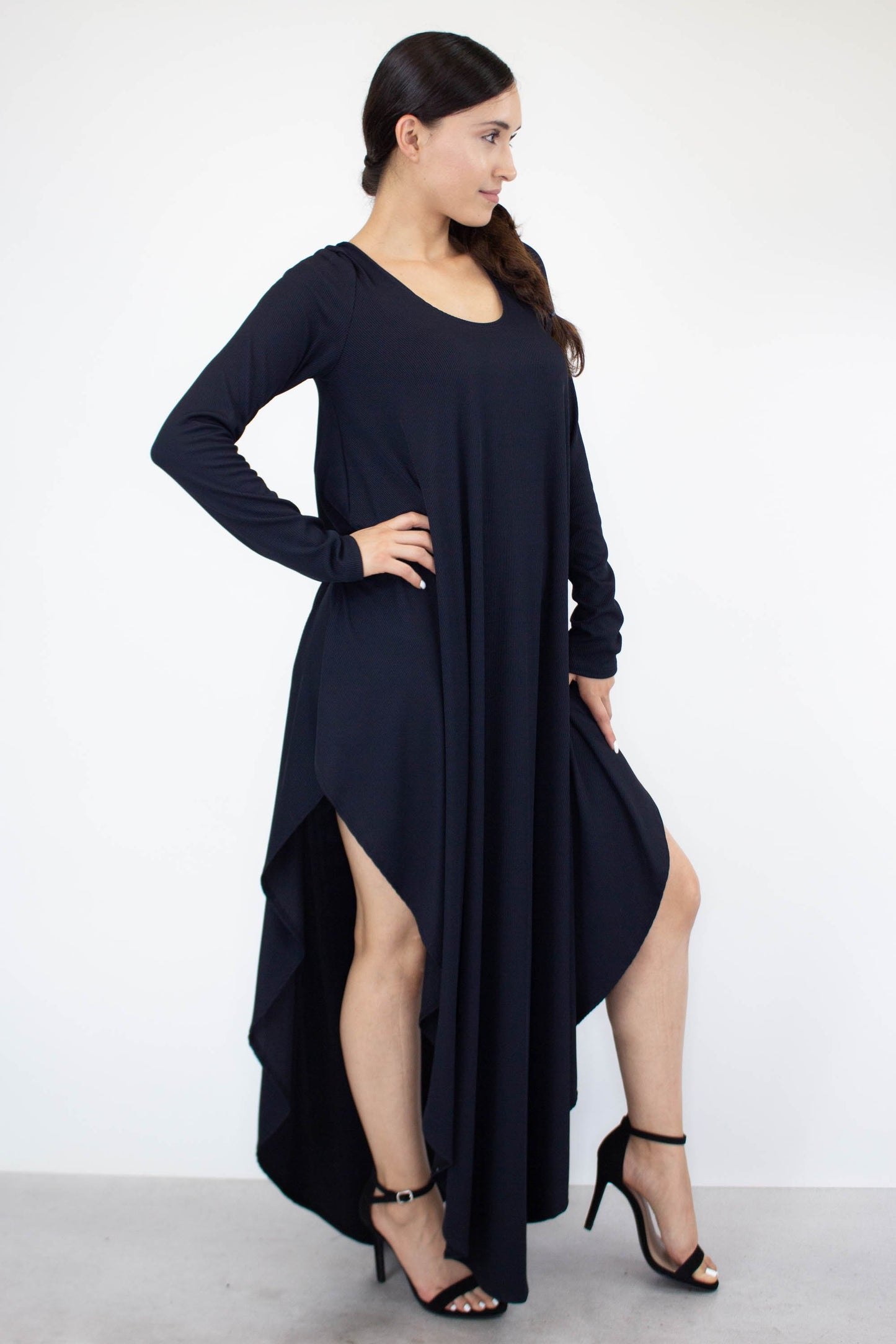 A person is wearing the Stylespect Asymmetric Long Sleeve Maxi Dress and high heels, standing against a plain white background.