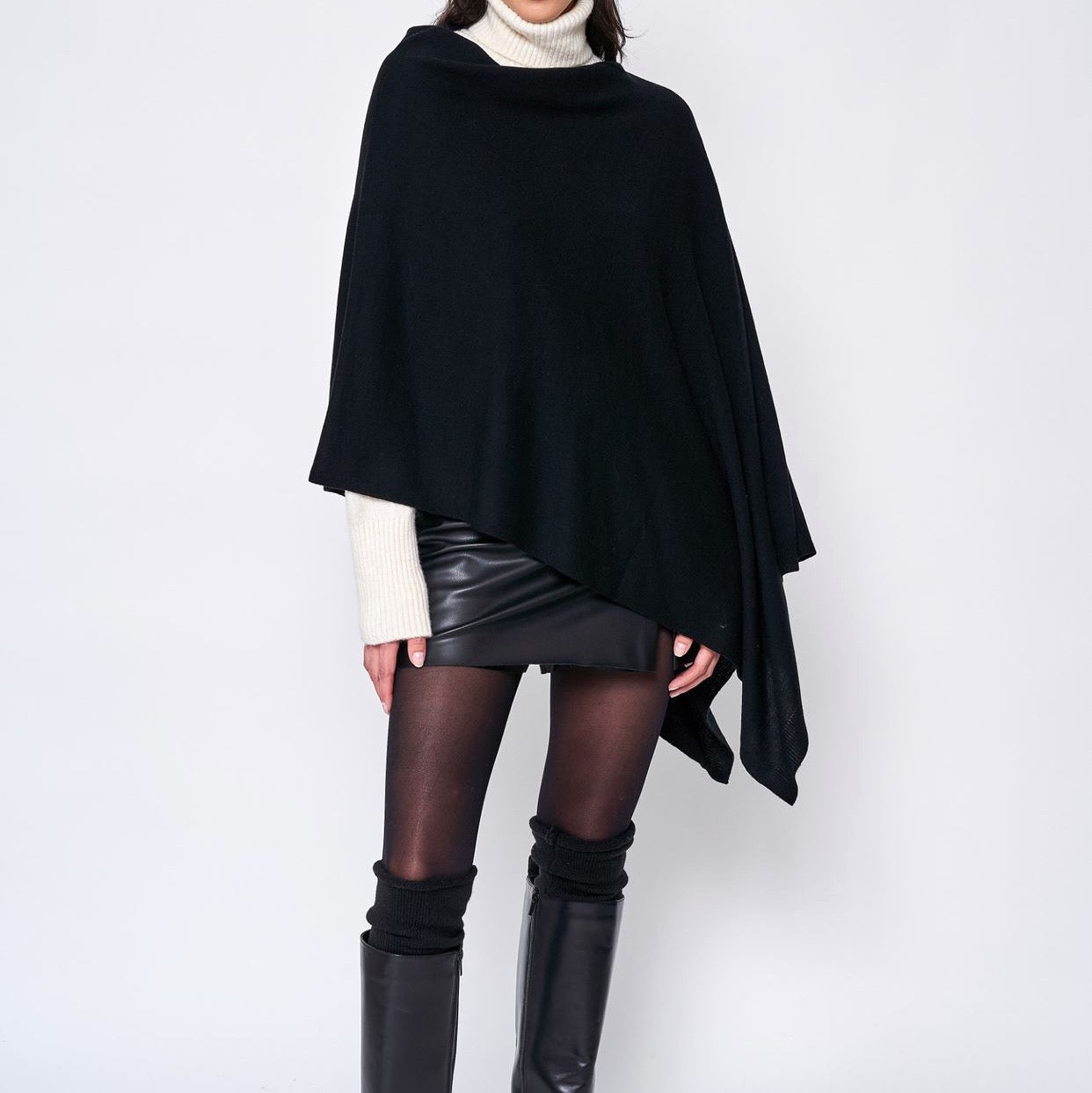 Someone wearing the Take With Me Travel Poncho by Ellison + Young with plaid pants against a plain white background.