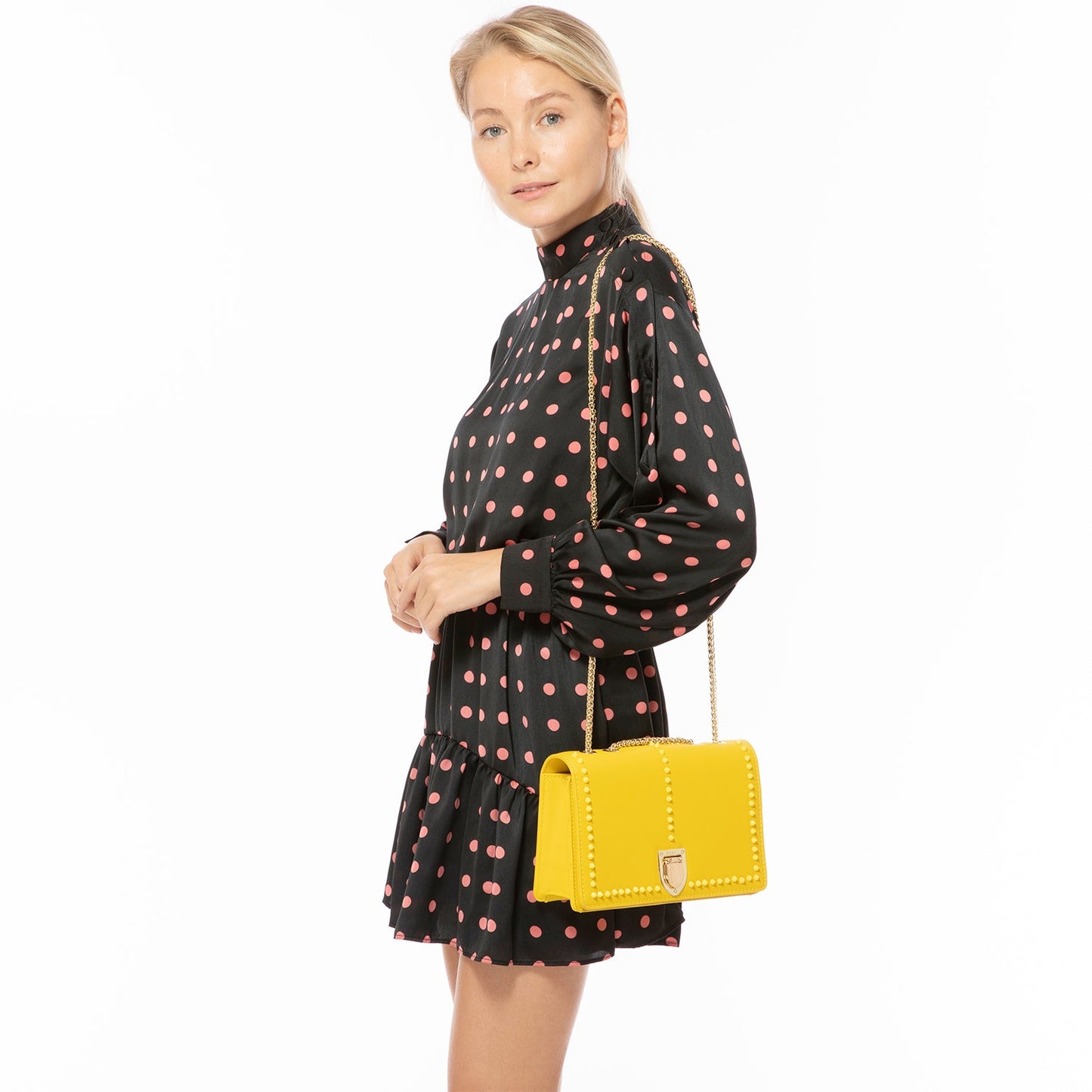 The SUSU Josie Mustard Yellow Leather Purse features gold chain straps, a clasp, and a front row of small studs.