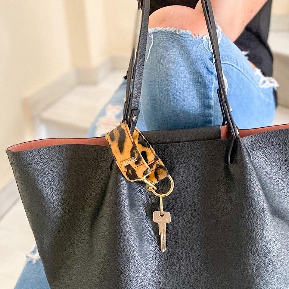 The KEYPER Brown Leopard Vegan Leather Key Ring is a wristlet keychain with a metal key and gold clasp.