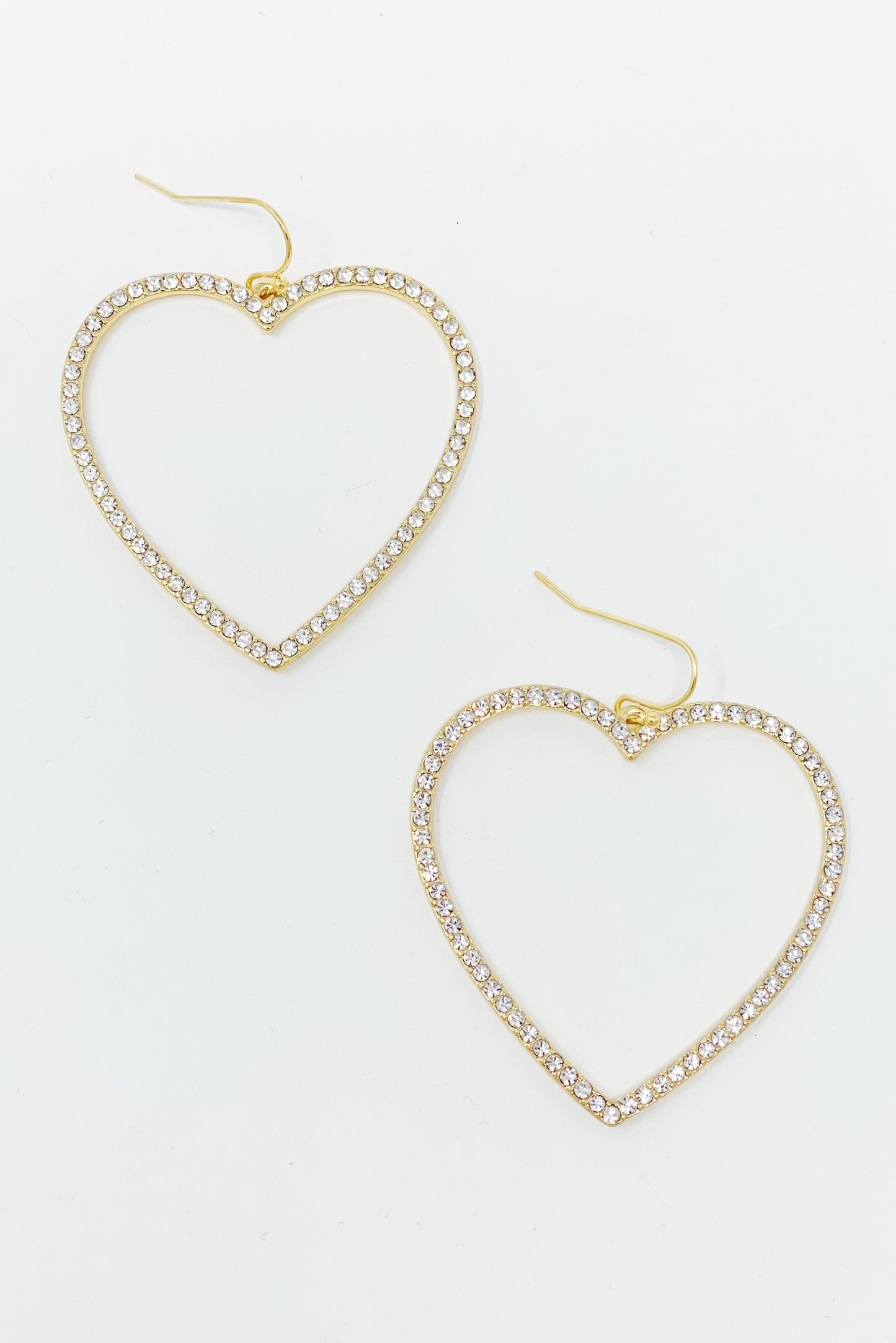 The My Precious Heart Earrings by Ellison + Young feature two gold heart-shaped designs adorned with rhinestones, shown on a white background.