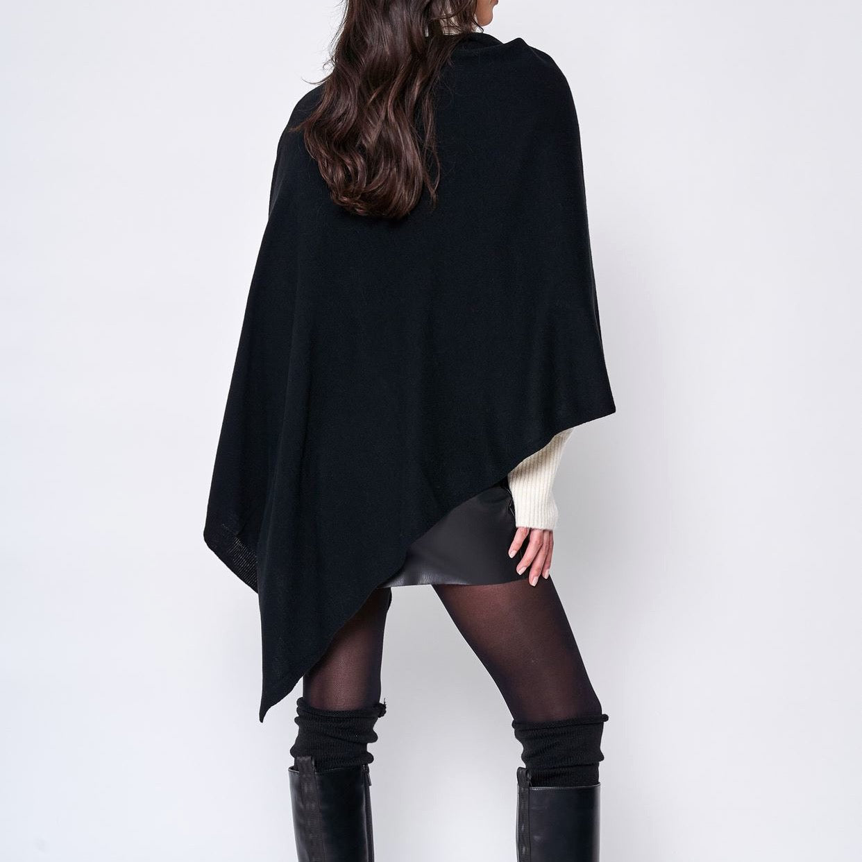 Someone wearing the Take With Me Travel Poncho by Ellison + Young with plaid pants against a plain white background.