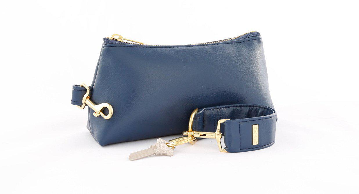 A compact True Navy vegan leather bag by KEYPER, with a gold zipper and clasp, comes with a detachable strap and includes a silver key attached to a key ring. Part of the 2-piece wristlet set.
