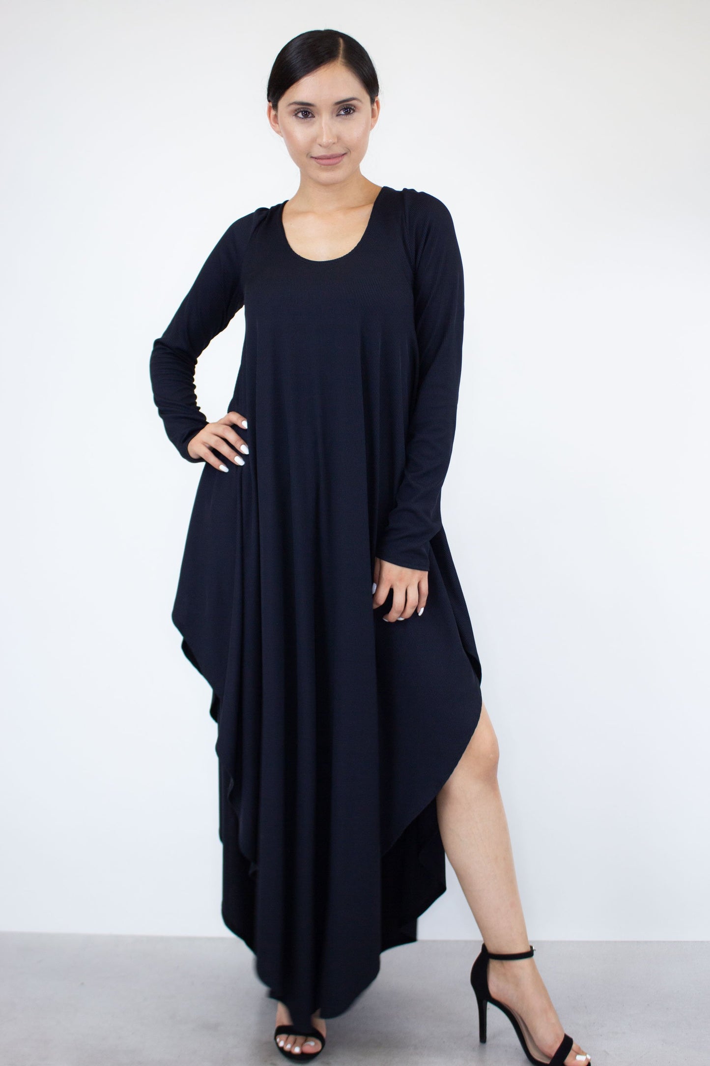 A person is wearing the Stylespect Asymmetric Long Sleeve Maxi Dress and high heels, standing against a plain white background.