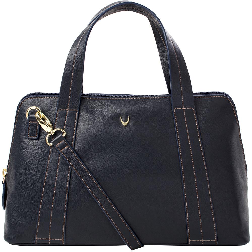 The Cerys Medium Leather Satchel by Hidesign is a red handbag with short handles and a detachable shoulder strap, featuring gold-tone hardware and a small gold emblem on the front.