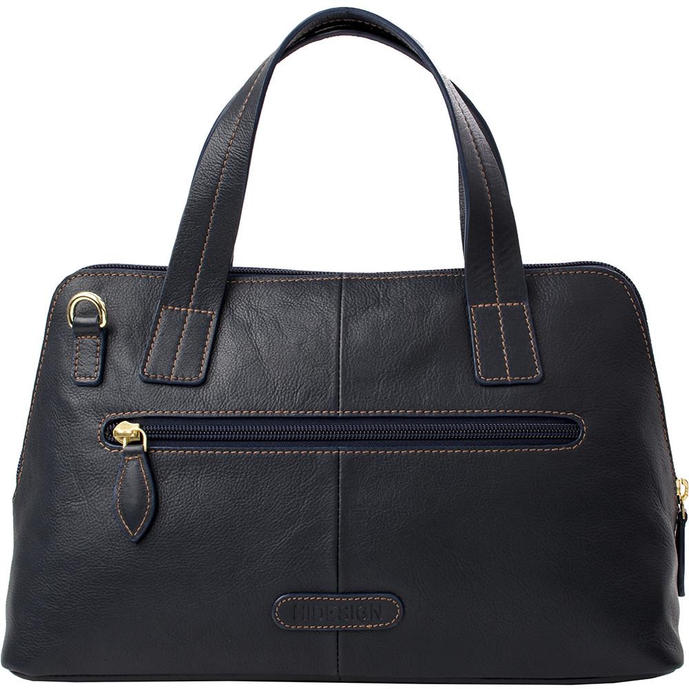 The Cerys Medium Leather Satchel by Hidesign is a red handbag with short handles and a detachable shoulder strap, featuring gold-tone hardware and a small gold emblem on the front.
