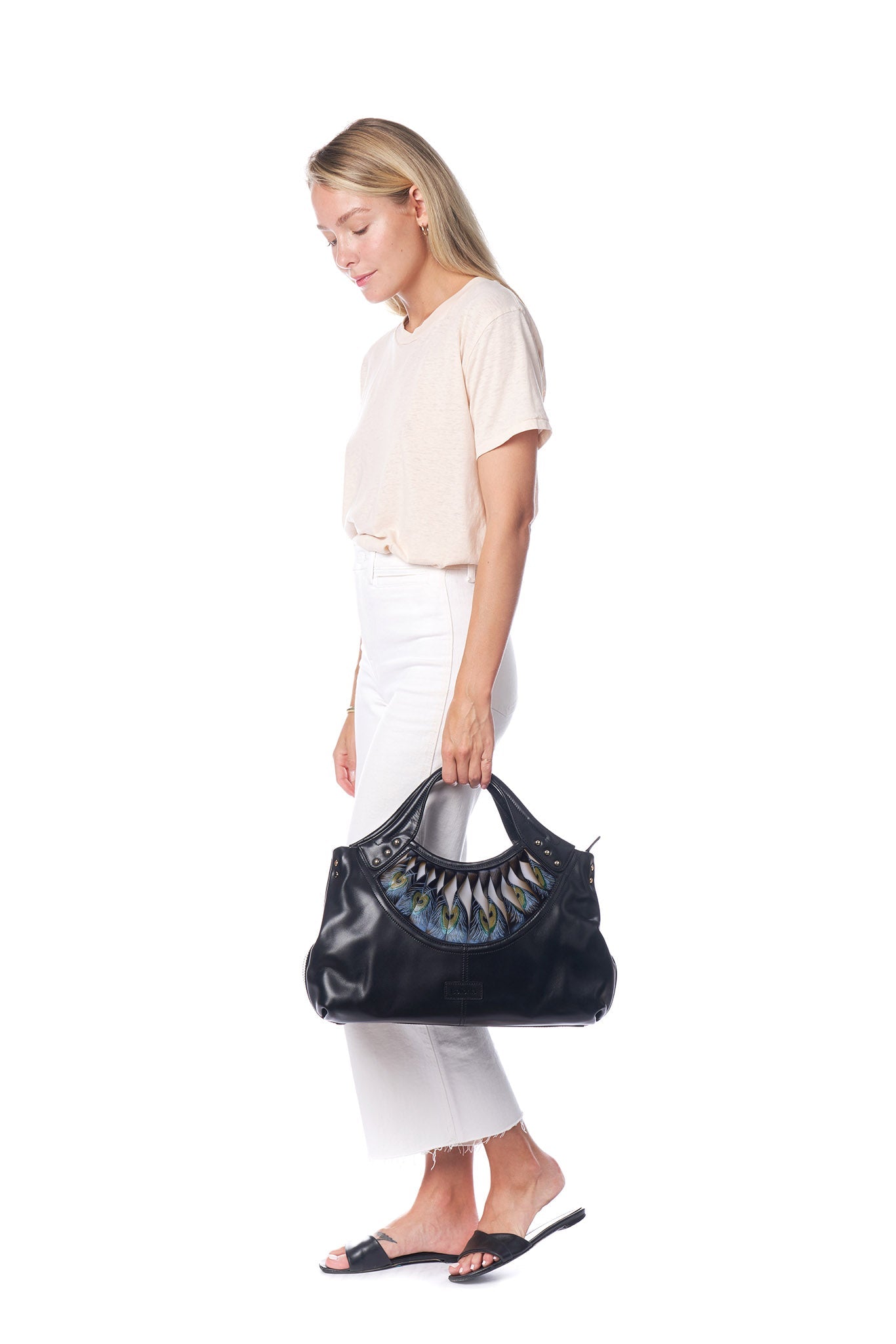 The Bellorita Feather Black Tote is a black leather handbag featuring a decorative peacock feather pattern near the handle, adorned with small metal studs.