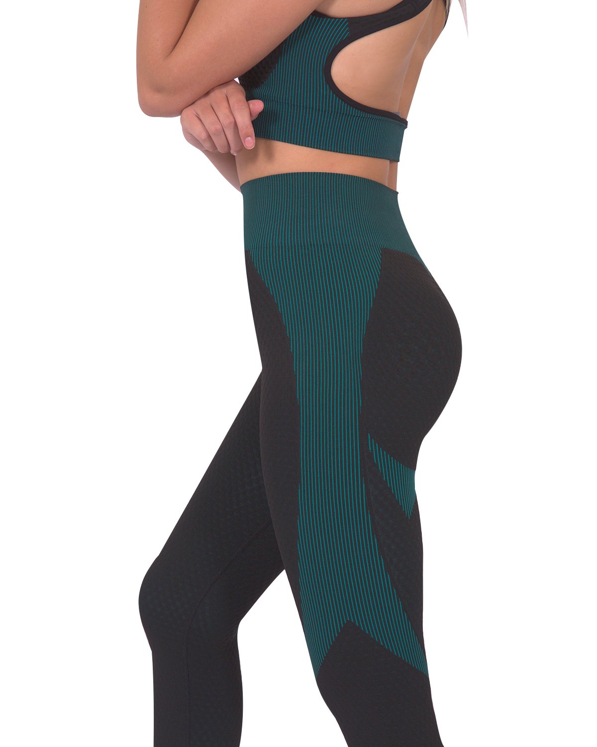 A person wearing Savoy Actives Trois Seamless Legging in Black with Teal Blue and black sneakers stands against a gray textured wall.