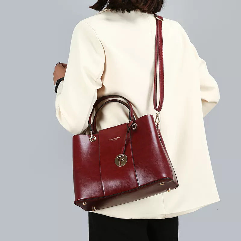 The Aaliyah Faux Crocodile Handbag Set by Savoy Active includes a maroon handbag with black handles and a small charm, plus a matching wallet.