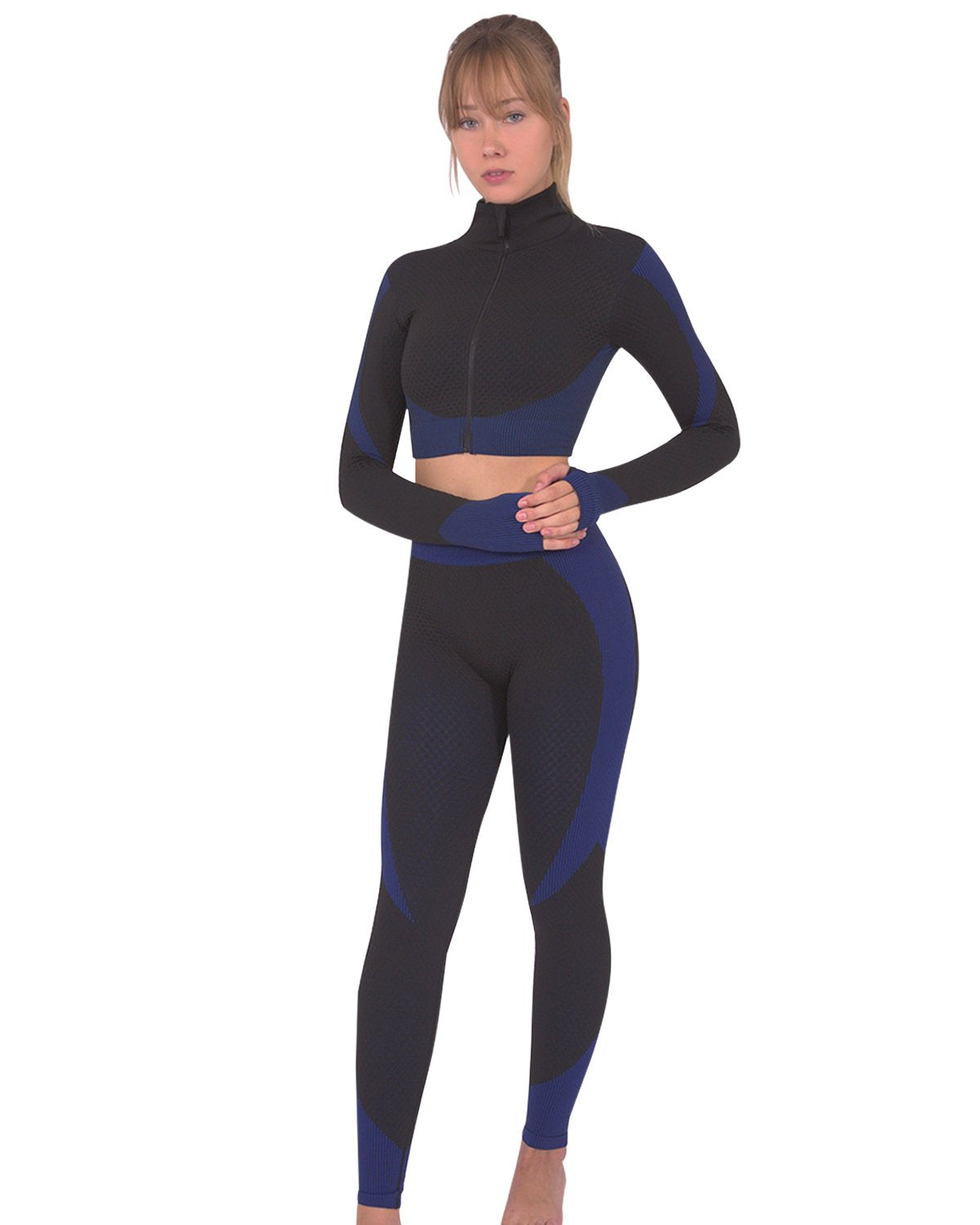 Someone wearing Savoy Actives Trois Seamless Legging in Black with Navy stands on a brown couch in a modern room with plants.