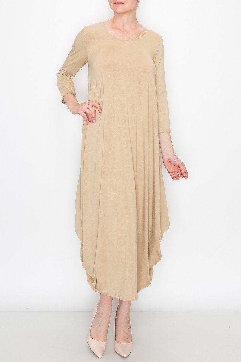 A person poses against a white background wearing the Stylespect Solid Balloon Dress in beige, featuring long sleeves and paired with beige heels, with one hand on their hip.