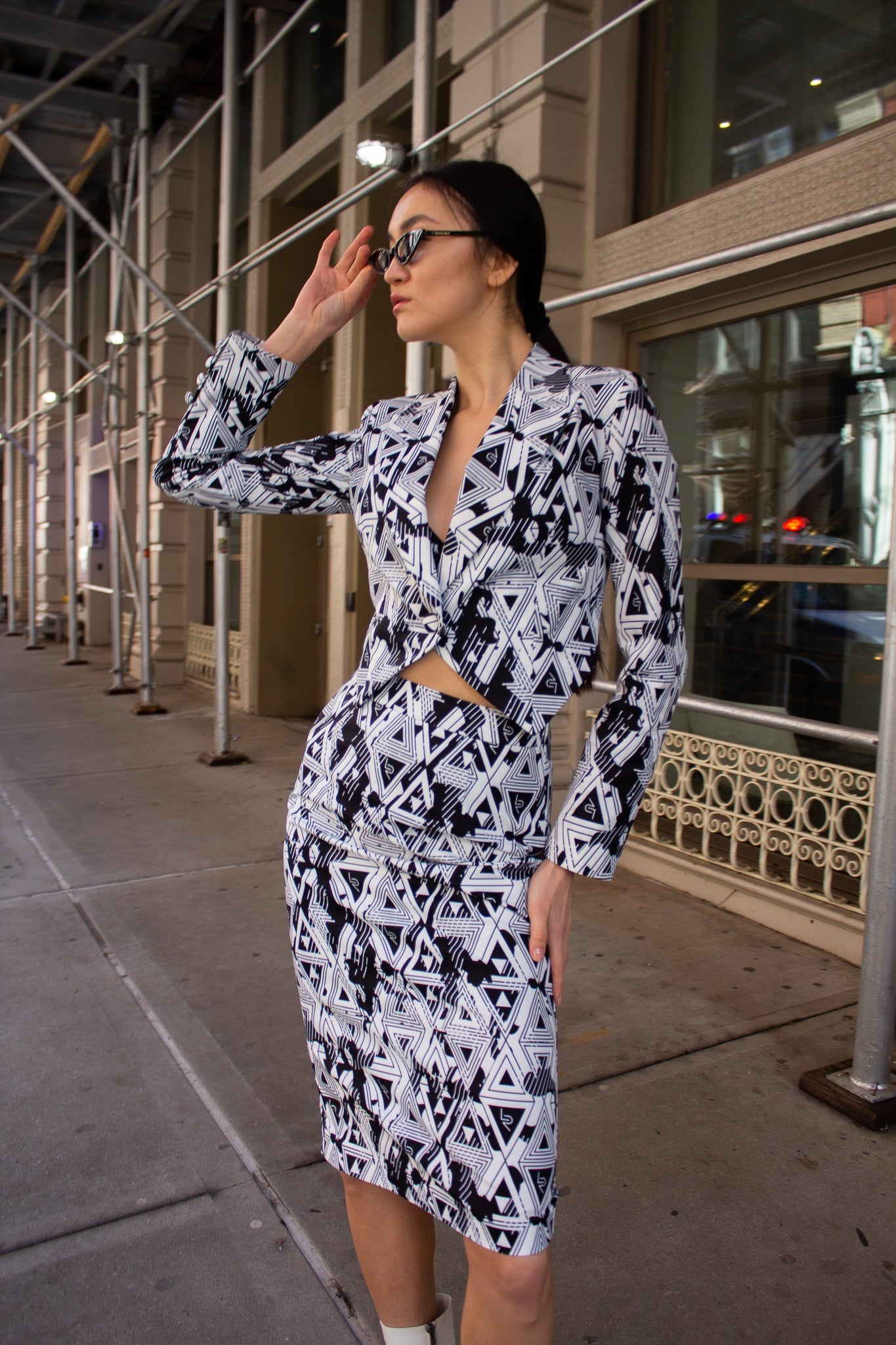 The Amour Geometric Pencil Skirt by Le Réussi® showcases a black and white geometric pattern with triangular shapes and abstract designs.