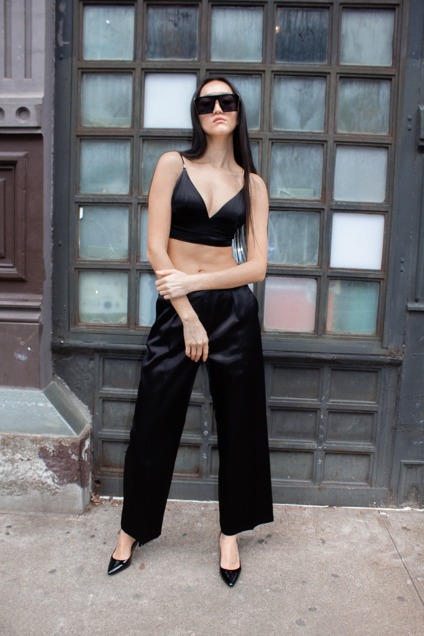 The Avril Crop Top by Le Réussi® is a black velvet bralette with thin straps, a soft sheen, and a slightly curved neckline.