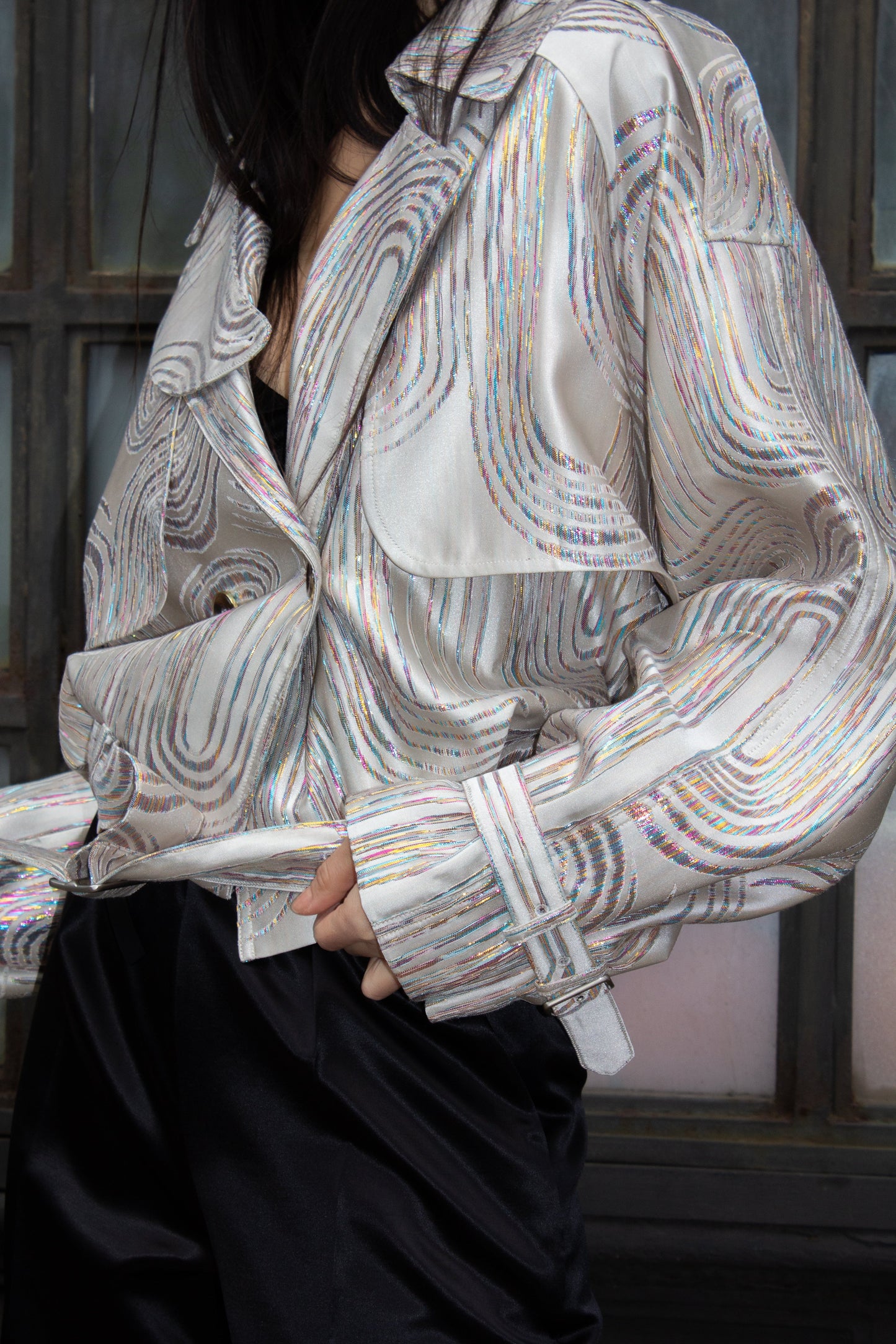 Jacqueline Beige Jacket by Le Réussi® features a white and silver pattern in a double-breasted design with a belt and buttoned cuffs, shown against a white background.