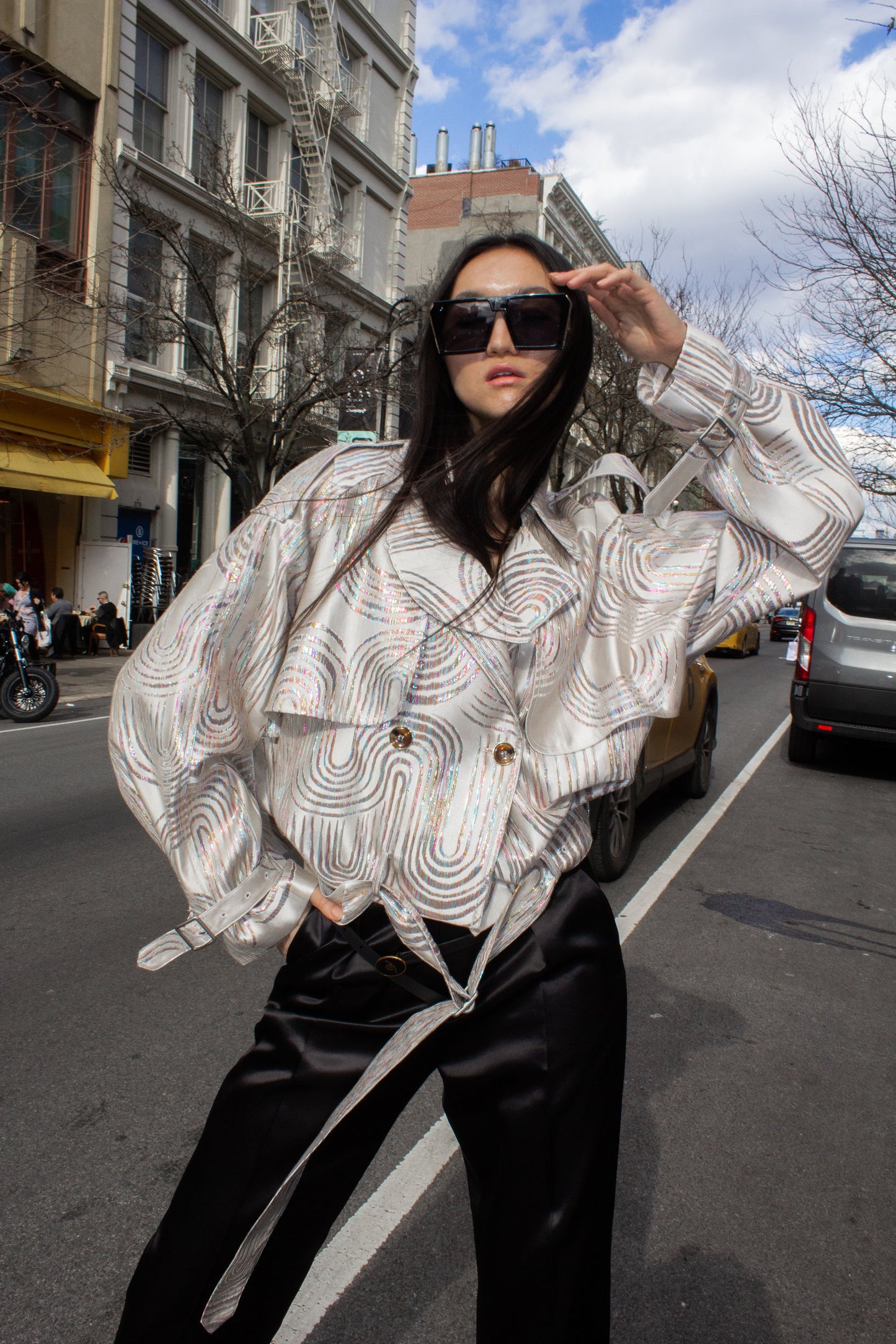 Jacqueline Beige Jacket by Le Réussi® features a white and silver pattern in a double-breasted design with a belt and buttoned cuffs, shown against a white background.