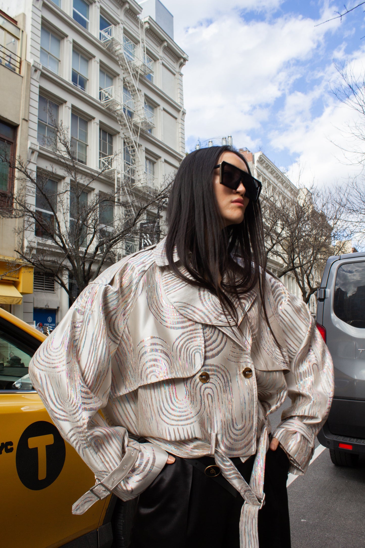 Jacqueline Beige Jacket by Le Réussi® features a white and silver pattern in a double-breasted design with a belt and buttoned cuffs, shown against a white background.