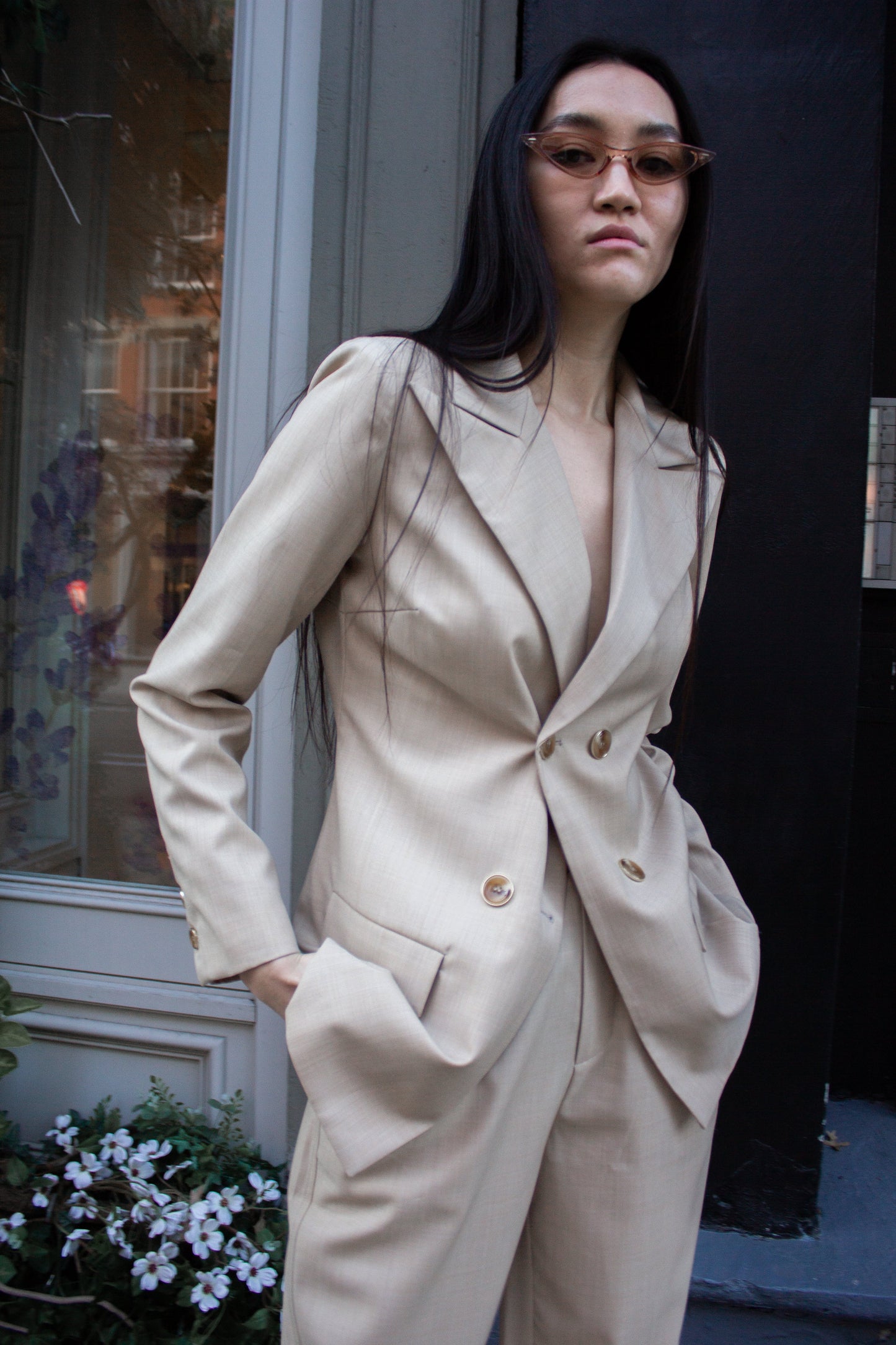 The Louise Blazer by Le Réussi® is a beige, double-breasted blazer featuring four buttons and two front pockets.